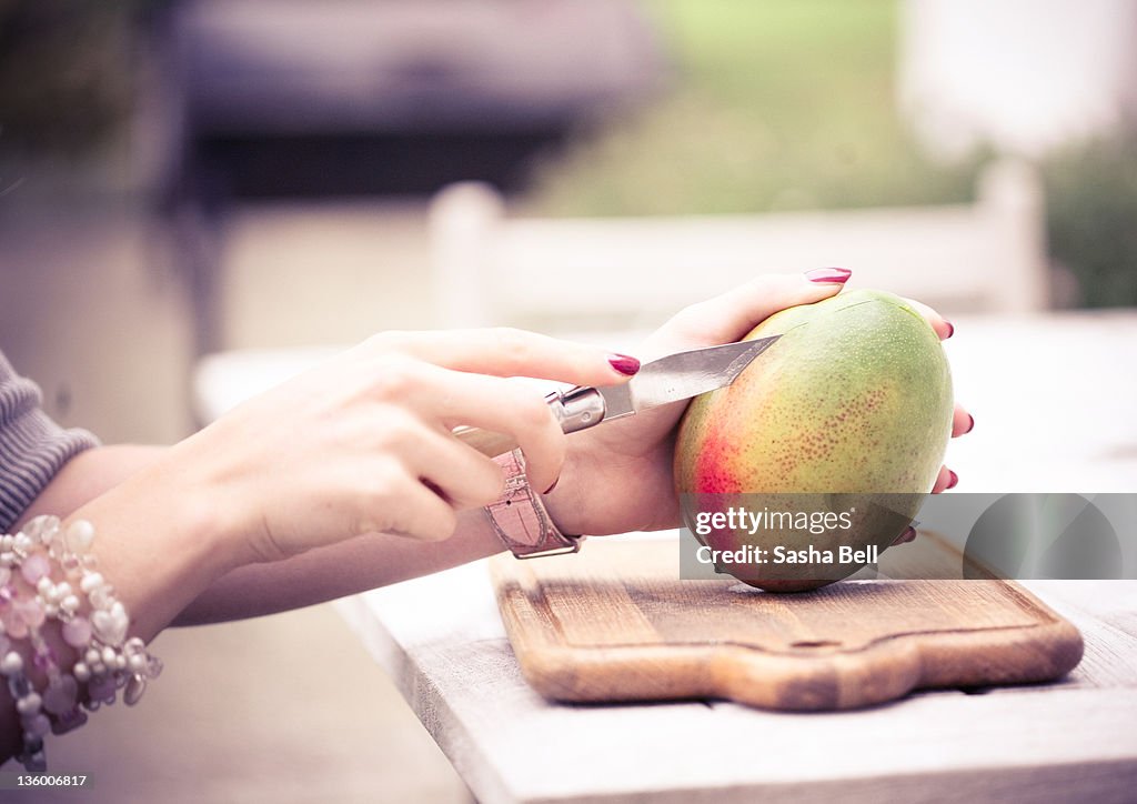 Person cutting Mango