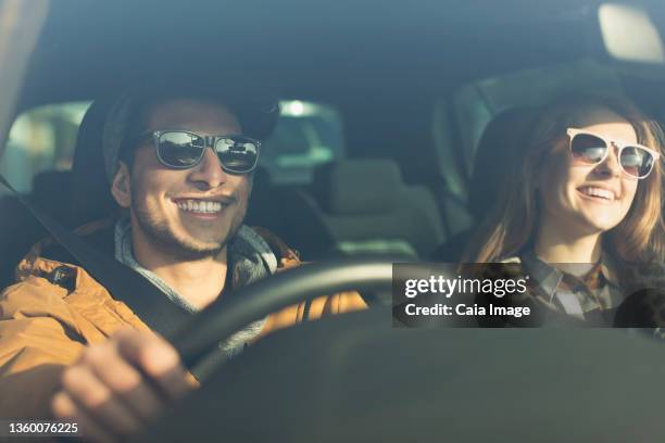 happy young couple wearing sunglasses in car - vie londres soleil photos et images de collection