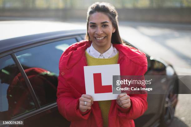 portrait confident, happy young woman holding learners permit - learner driver stock-fotos und bilder