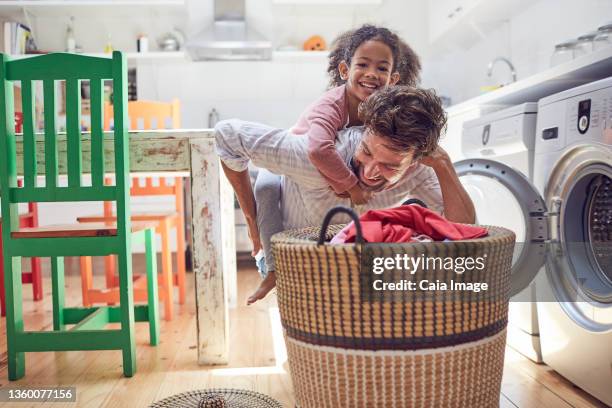 playful father and daughter doing laundry - laundry basket imagens e fotografias de stock