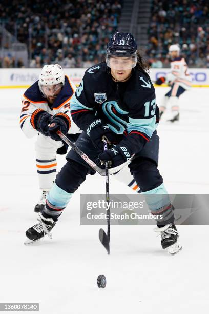 Brendan Perlini of the Edmonton Oilers defends Brandon Tanev of the Seattle Kraken during the first period at Climate Pledge Arena on December 18,...