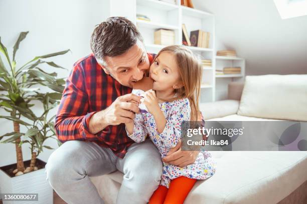 vater und seine kleine tochter haben spaß beim gemeinsamen schokoladenessen - child loves chocolates stock-fotos und bilder