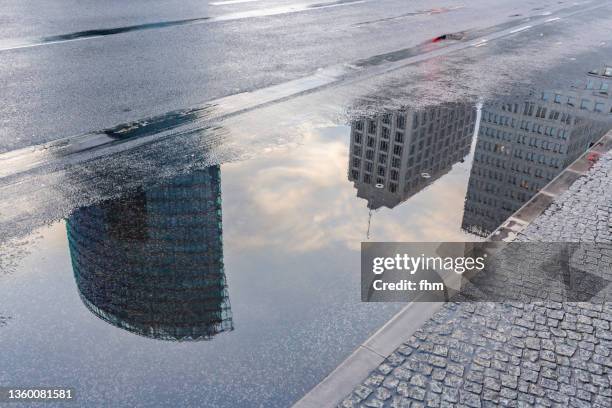 reflection in a puddle - potsdamer platz berlin after rain (germany) - puddle reflection stock pictures, royalty-free photos & images