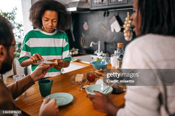 daughter serving father with bread in kitchen - making sandwich stock pictures, royalty-free photos & images