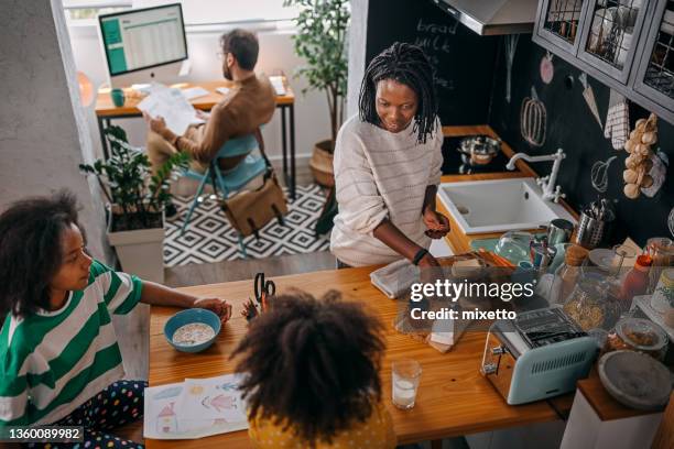happy family in kitchen working and studying - ocupado imagens e fotografias de stock