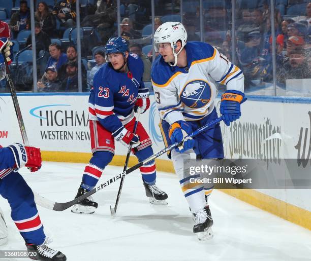 Mark Pysyk of the Buffalo Sabres skates against Adam Fox of the New York Rangers during an NHL game on December 10, 2021 at KeyBank Center in...