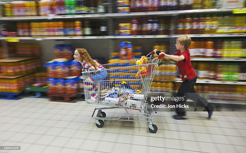 Children playing with a shopping trolley.