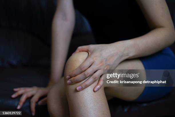 closeup girl sitting on sofa and feeling knee pain , health care and medical concep,leg pain - joint body part stock pictures, royalty-free photos & images
