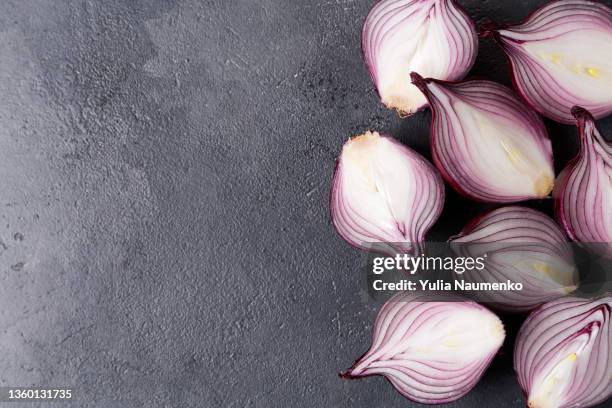 fresh red onions on a black table. halves of onions, copy space - cortar cebola imagens e fotografias de stock