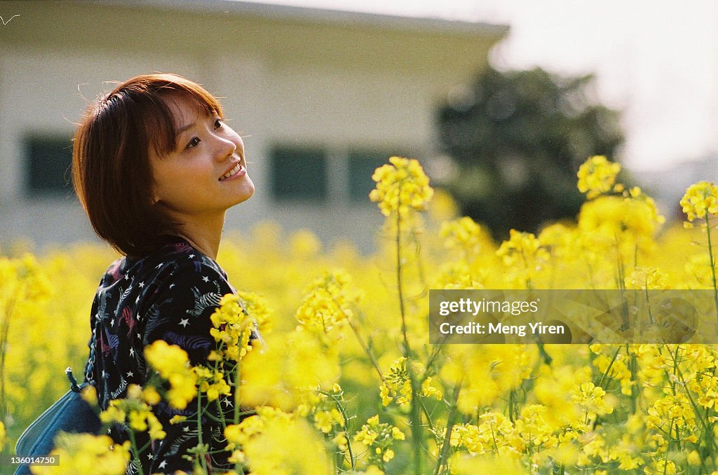 Girl standing in yellow flower field