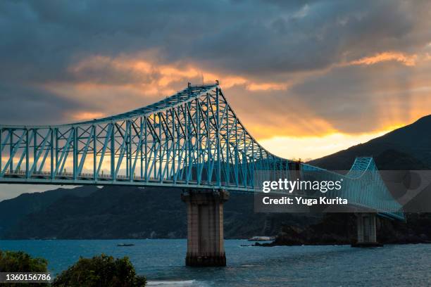 生月島と平戸島を結ぶ生月大橋とドラマチックな朝焼けの空 (ikitsuki bridge connecting the ikitsuki and hirado islands) - truss bridge stock pictures, royalty-free photos & images