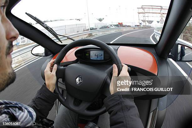 Man drives a new Renault electric car Twizy Z.E, on a test track, on December 20, 2011 at the Ile Séguin test centre for electric vehicles in...