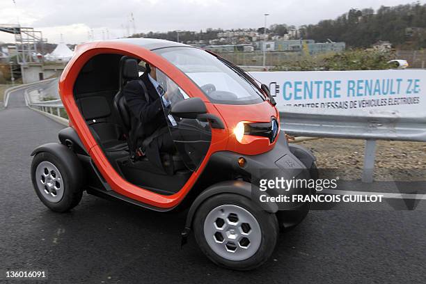 Man drives a new Renault electric car Twizy Z.E, on a test track, on December 20, 2011 at the Ile Séguin test centre for electric vehicles in...