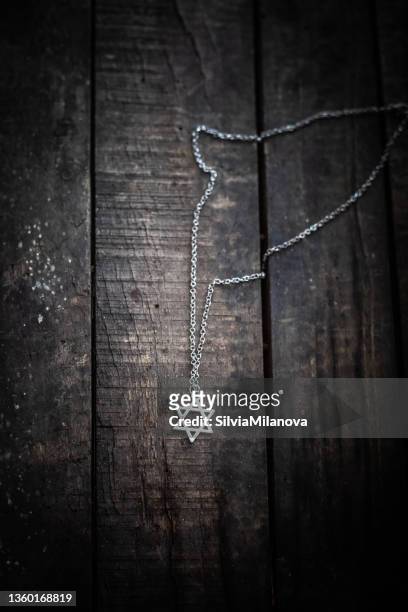 star of david necklace on a wooden table - judenstern stock-fotos und bilder