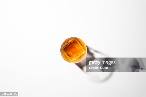 overhead view of a glass of whisky on a white background - bourbon whisky stockfoto's en -beelden
