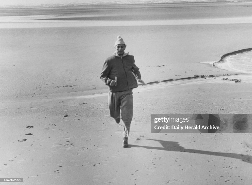 Stanley Matthews jogging on the beach in Blackpool at Squires Gate, prior to his return to Stoke City, 1961
