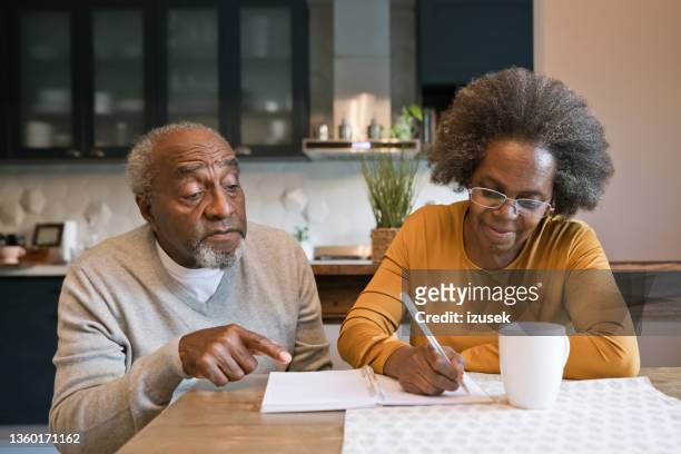 senior couple making to do list - writing list stock pictures, royalty-free photos & images