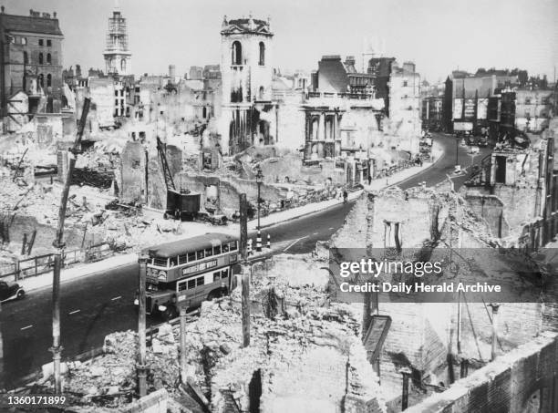 Bomb damage in Victoria Street in London, following the Blitz, September 1941. A double- decker bus passes along the road between ruined buildings.