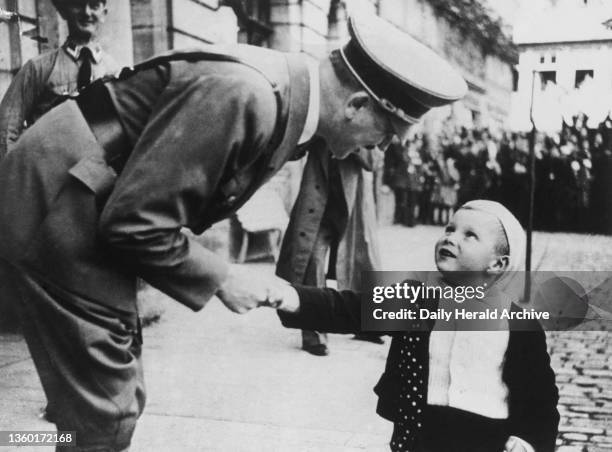 Year old boy receiving Adolf Hitler in Coburg, 1935. A photograph of a 3 year old boy receiving Adolf Hitler in Coburg, on the occasion of the...