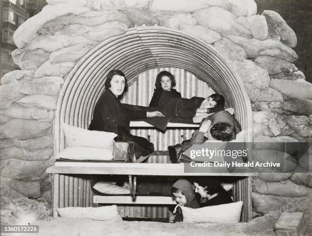 An Anderson shelter. A photograph of a family in an Anderson air raid shelter. 'Sleeping accommodation for 8 persons in Anderson Shelter designed by...