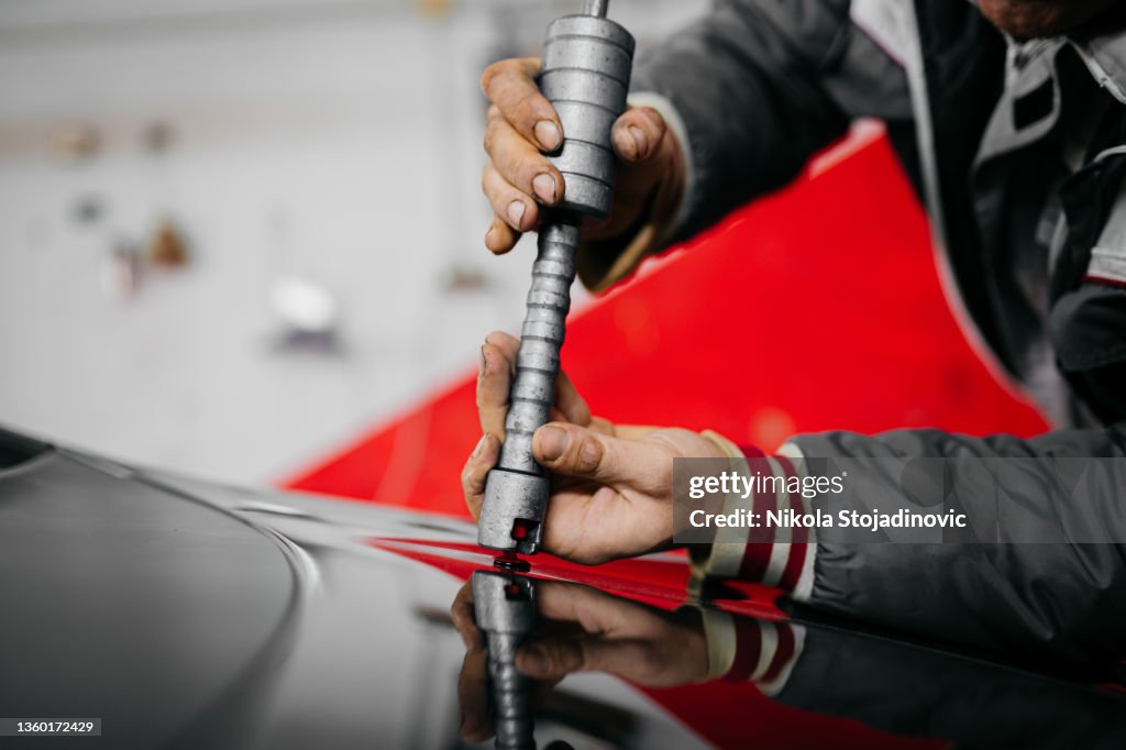 Mécanicien de carrosserie démontage d’un véhicule endommagé