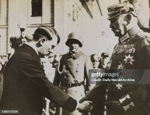 Hilter and Hindenberg shake hands in Potsdam, 1933. A photograph of Chancellor Adolf Hitler and President Hindenberg shaking hands after the opening...