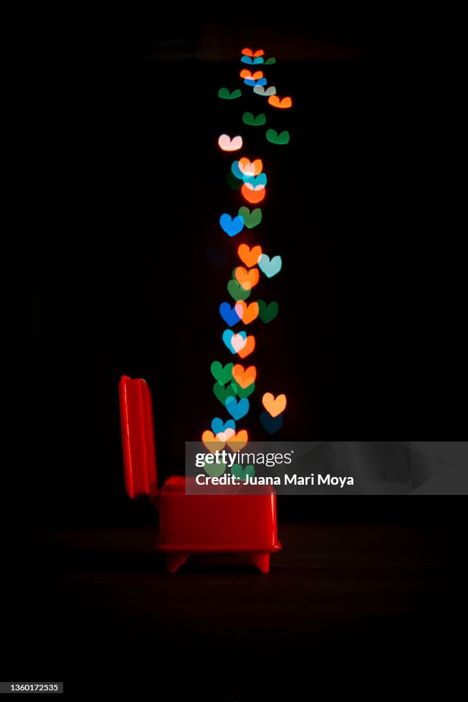 Luminous heart shapes come out of a jewelry box. Creative photography, love concept
