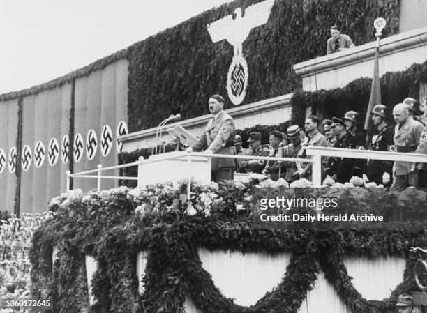 Adolf Hitler addressing the crowd from a balcony during a Nazi Party rally, circa 1937. A photograph of Adolf Hitler addressing the crowd from a...