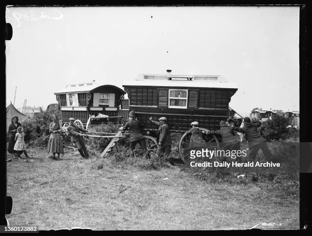 Police moving on a Romany caravan, 1935. A photograph of police officers moving on a Romany caravan from a site on Epsom Downs, Surrey, taken by...
