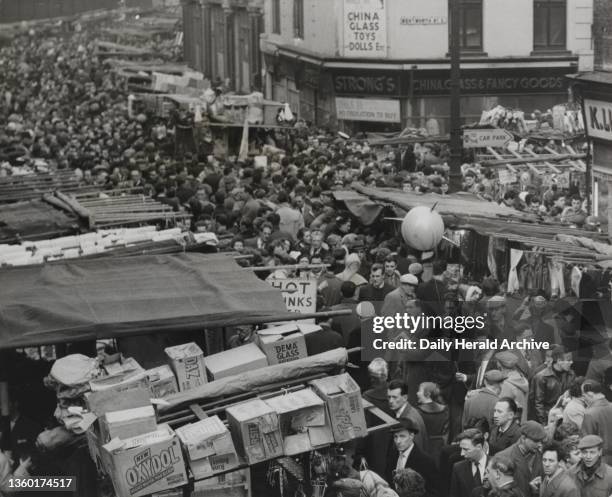 Sputnik in London, 1957. Above the sea of heads of the Christmas shoppers crowded in London's famous Petticoat Lane a Sputnik balloon floats...