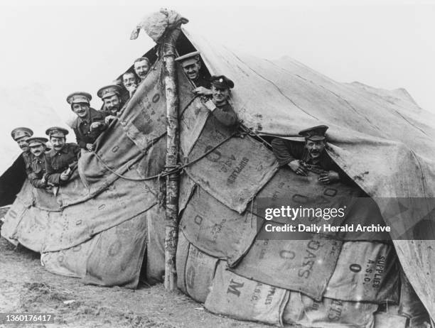 British soldiers looking out from their improvised tent, 1914-1918. British soldiers looking out from their improvised tent, made from sandbag...