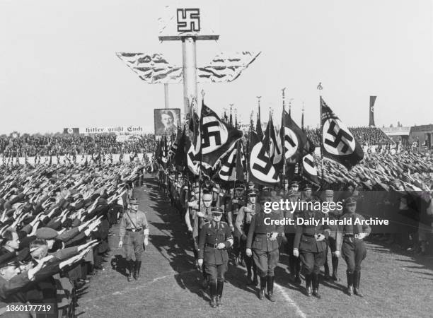 Crowds giving the Nazi salute as soldiers march past, Nuremberg, 1937