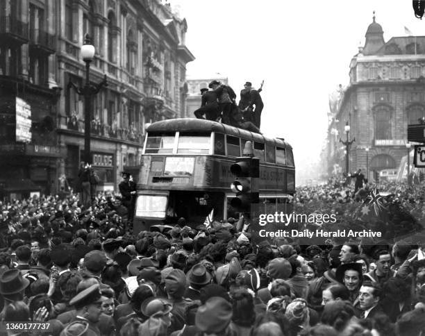 Crowds in Piccadilly Circus in Central London, celebrating on the eve of VE Day, 7 May 1945. Photograph by F Greaves.