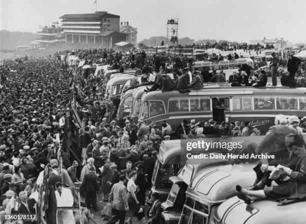 Derby day at Epsom, Surrey, 25 May 1955. A general view of the vast crowd, many of them sitting on top of coaches to get a better view of the track.