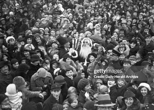 Father Christmas arriving at Selfridges department store in London, 30 October 1933. He is surrounded by a crowd of people. Photograph by Edward G...