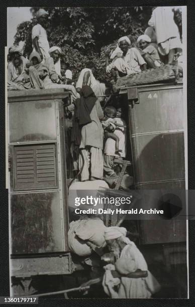 Muslim refugees crowd train as they flee India for Pakistan, 1947. Gelatin silver photograph shows Muslim refugees crowding the buffer area between...