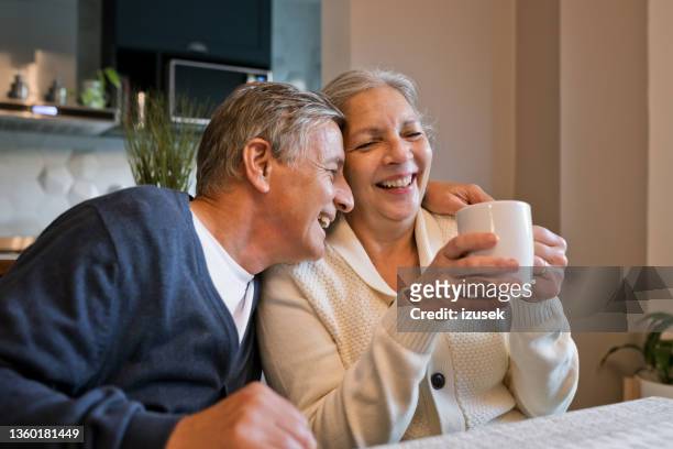 happy senior couple at home - retired couple stockfoto's en -beelden