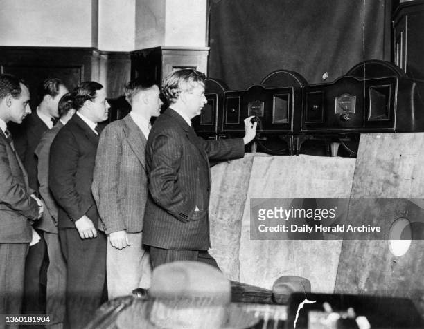 John Logie Baird , the television pioneer, watching a test transmission on his 30 line Model A 'televisor' television, at Long Acre in London, June...