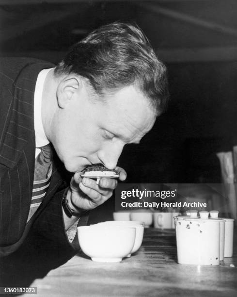 Man nosing the tea infusion during a trade competition, 26 April 1950. 'Tea blending competition at the Grocers and Allied Trades Exhibition at Belle...