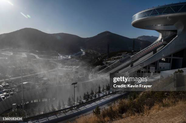 Snow machine makes artificial snow next to the National Ski Jumping Center, that will host events during the Beijing 2022 Winter Olympics, during a...