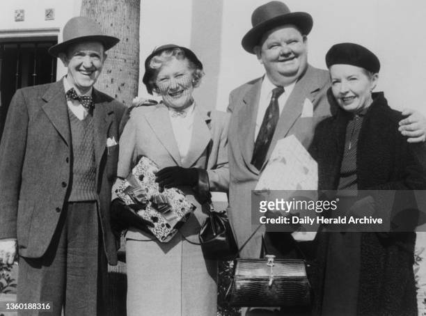 Stan Laurel and Oliver Hardy, who as a team have been fun-making for 25 years, with their wives Ida Laurel and Lucille Hardy on a personal appearance...