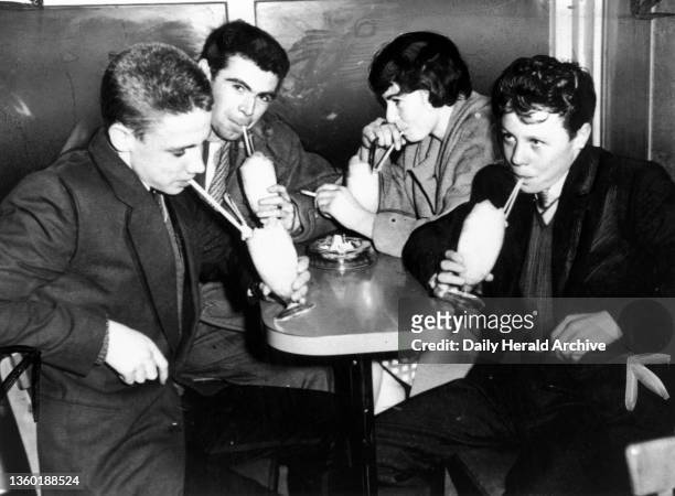 Teddy boys and girl drinking milk shakes, 21 October 1959. 'Teenagers want a place to meet, somewhere to do as they like. Here are four of the...