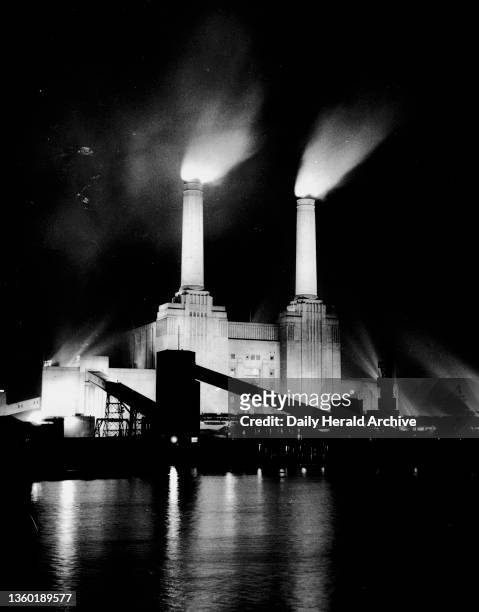 Battersea Power Station, London, 3 January 1956. The original caption for this photograph read: 'Battersea Power Station gleams brightly across the...