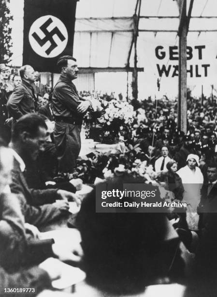 Adolf Hitler addressing over 30,000 people in a marquee in Munich on 4 July 1932. The meeting followed a parade of over 15,000 storm troops to...