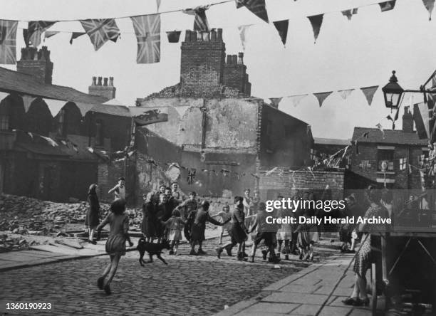Day Celebrations In Paradise Street, Salford, crowds from the few remaining households dance around a bonfire in the street