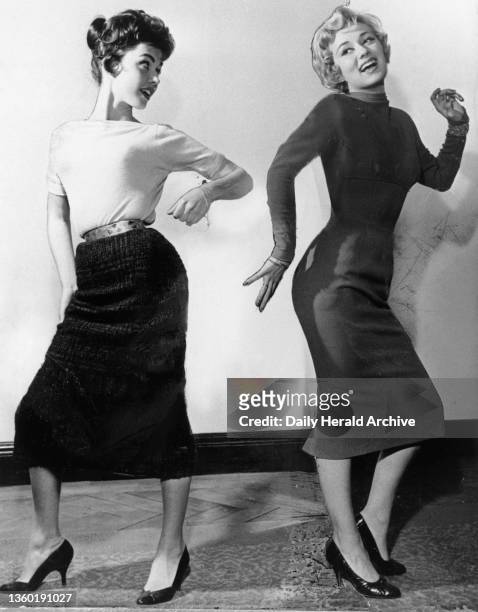 Two women dancing, 1957. Young women dancing to rock and roll music, wearing high-heeled stiletto shoes and pencil skirts.