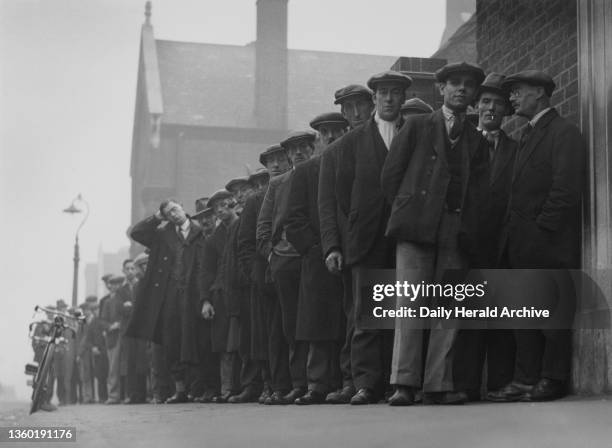 Unemployed men queuing at a labour exchange, October 1931. By August 1931, employment in Britain had risen to two million, its highest level since...