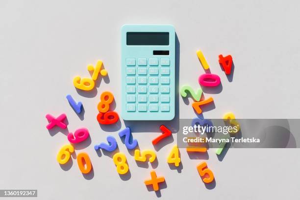 blue calculator and math symbols on a universal gray background. gray background. blue calculator. math symbols. - fun calculator stockfoto's en -beelden