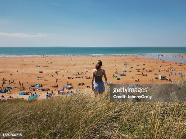 girl looking out onto woolacombe beach on sunny spring bank holiday - national holiday stock pictures, royalty-free photos & images