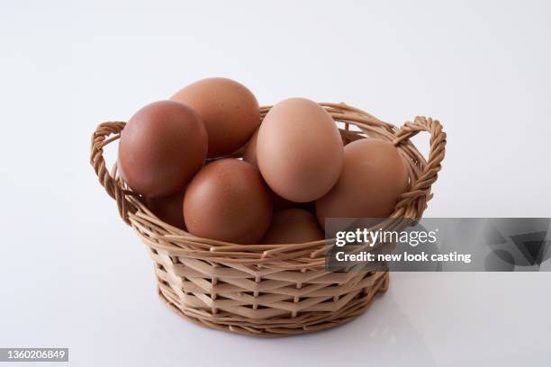 basket of eggs on white background - eggs basket stock pictures, royalty-free photos & images